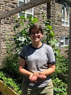 Rachel Gass at the Ardmore Victory Garden holding small potatoes