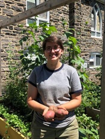 Rachel Gass at the Ardmore Victory Garden holding small potatoes