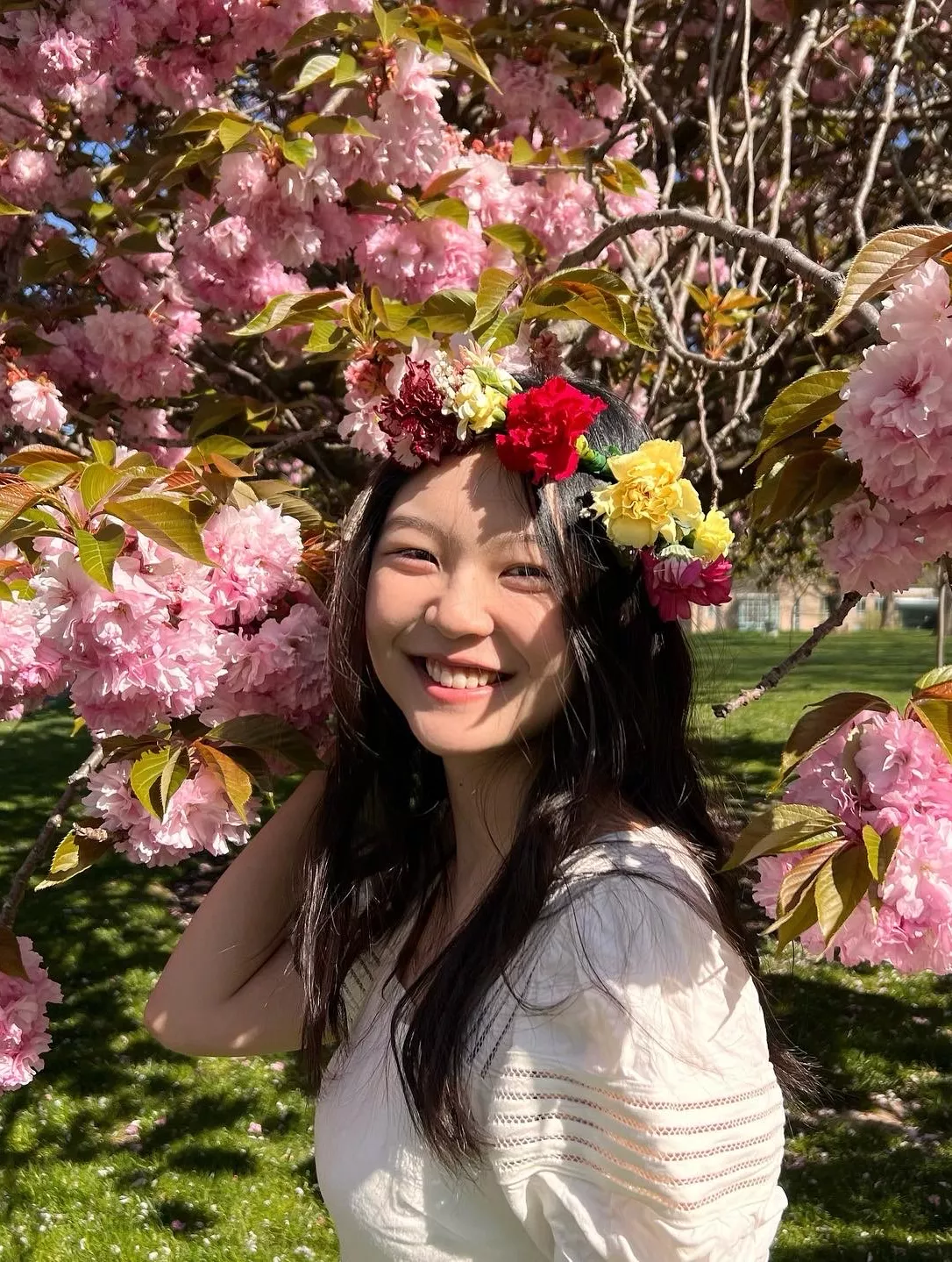 Sharon Liu in front of a cherry blossom tree. 