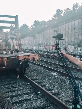 A dance group on a train car, with a photographer capturing their work