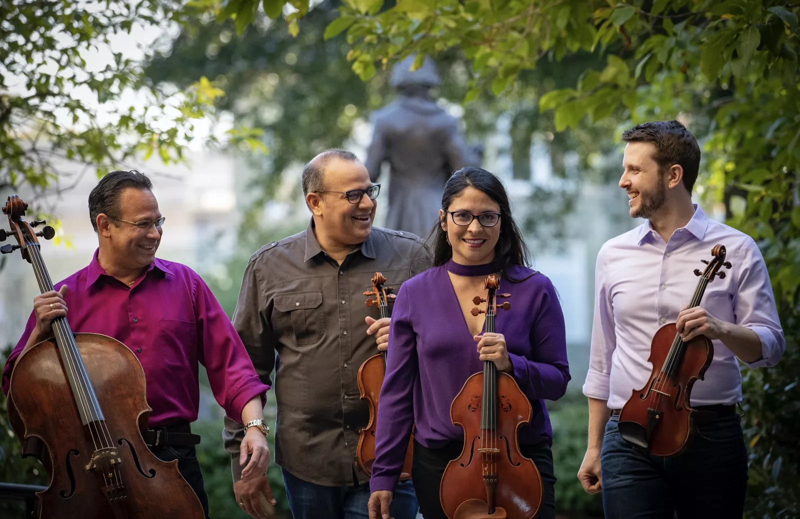Four musicians holding string instruments