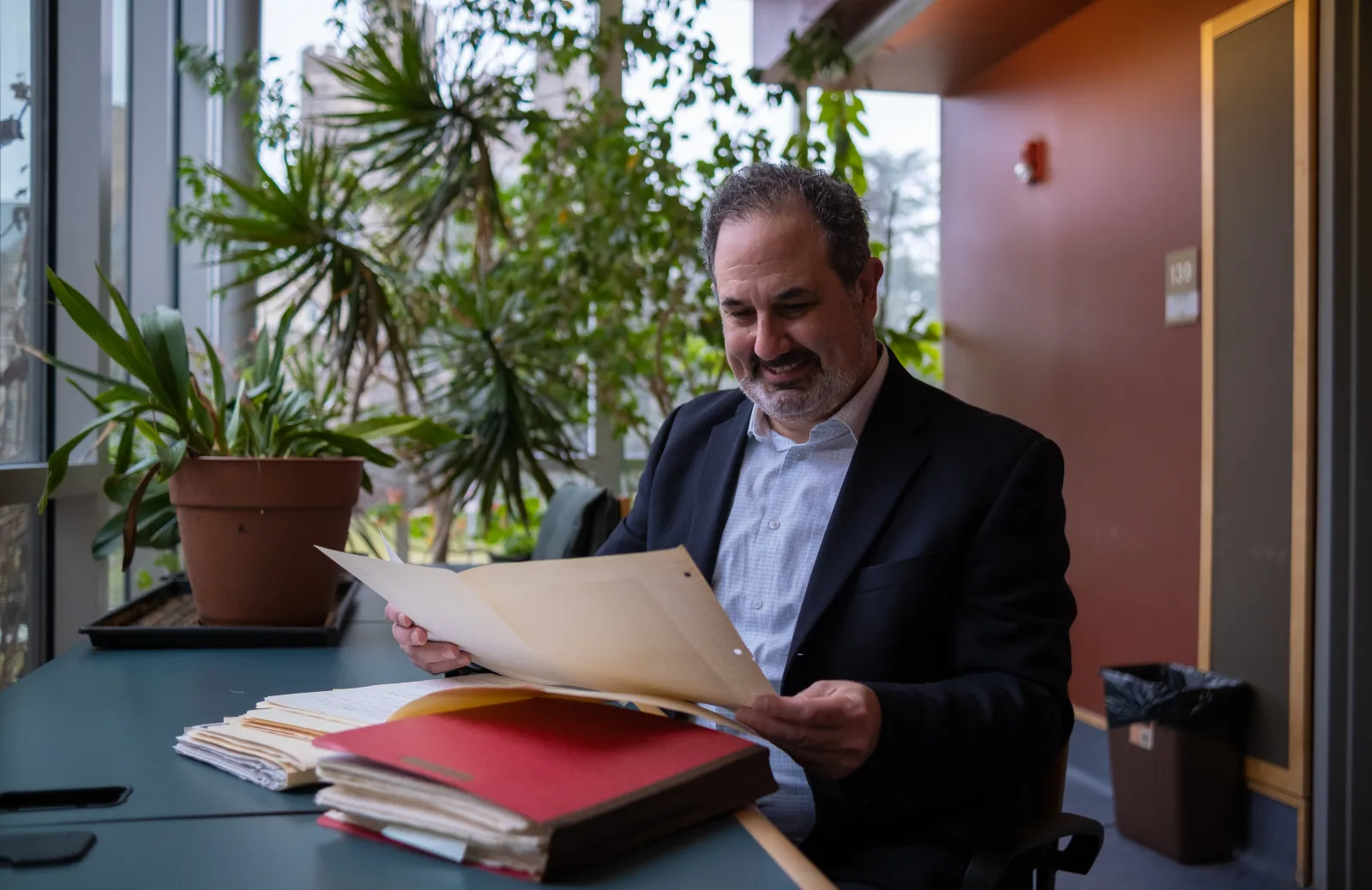 Marc Schulz smiling as he looks down at his files