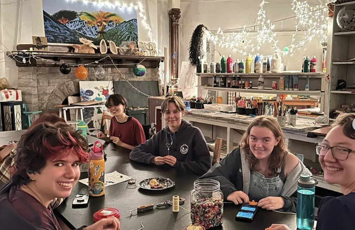Students seated at a table working on crafts. 