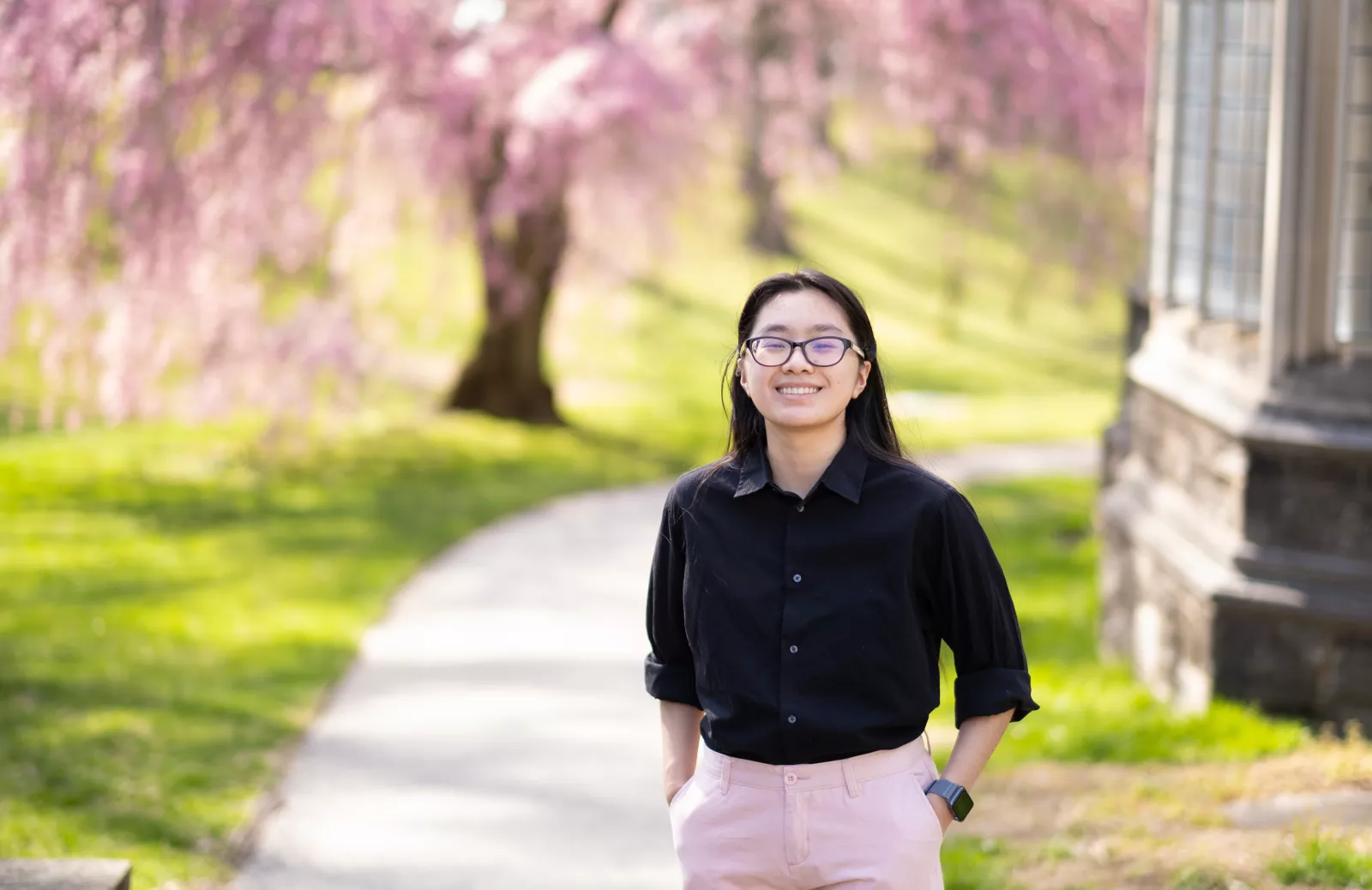 Glory Zhang in front of cherry blossom tree