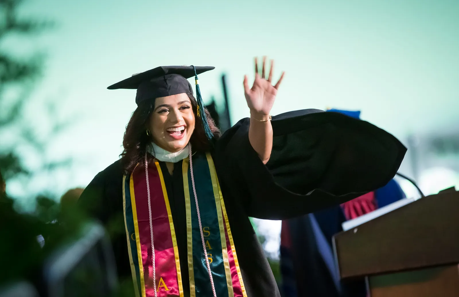 Graduate waving during Commencement