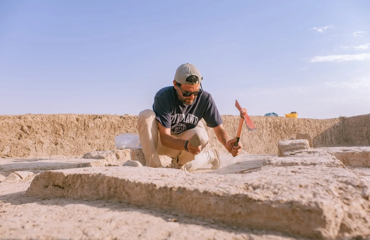 Rocco wearing a Bryn Mawr shirt at a dig site