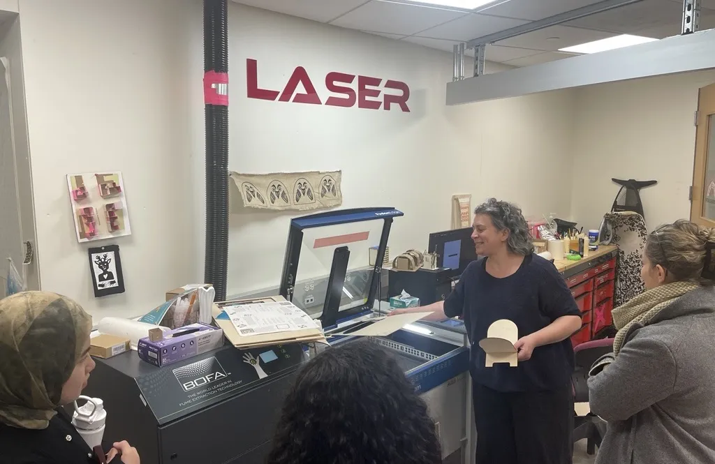Bronwen Densmore instructs attendees to a workshop on making rehals about how to use the laser cutter