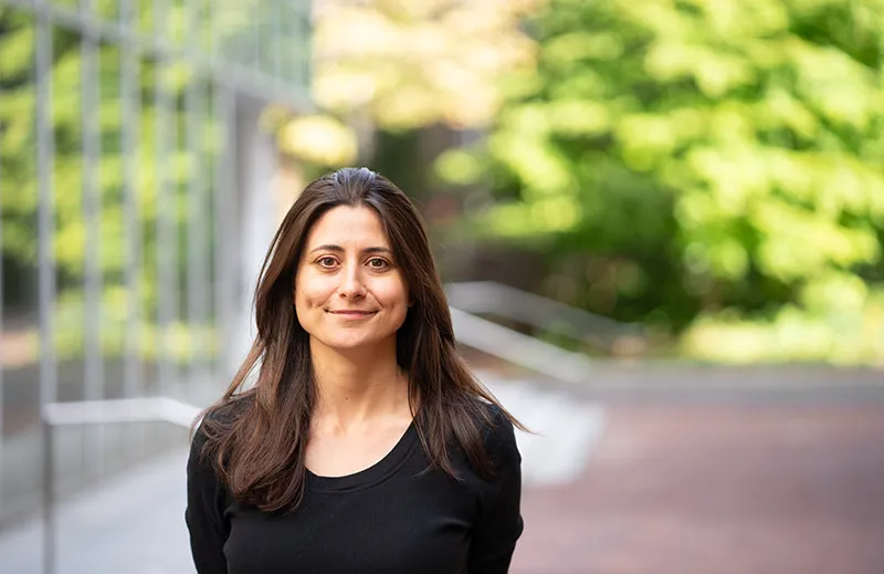 Arwa Mahdawi standing outside in front of building and trees