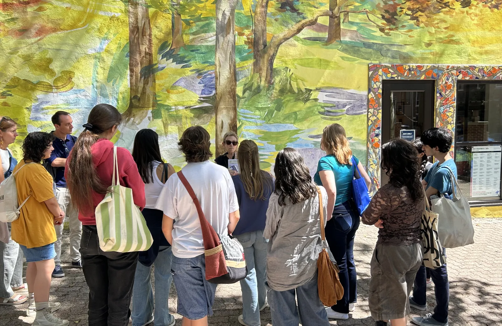Students looking at a colorful mural.