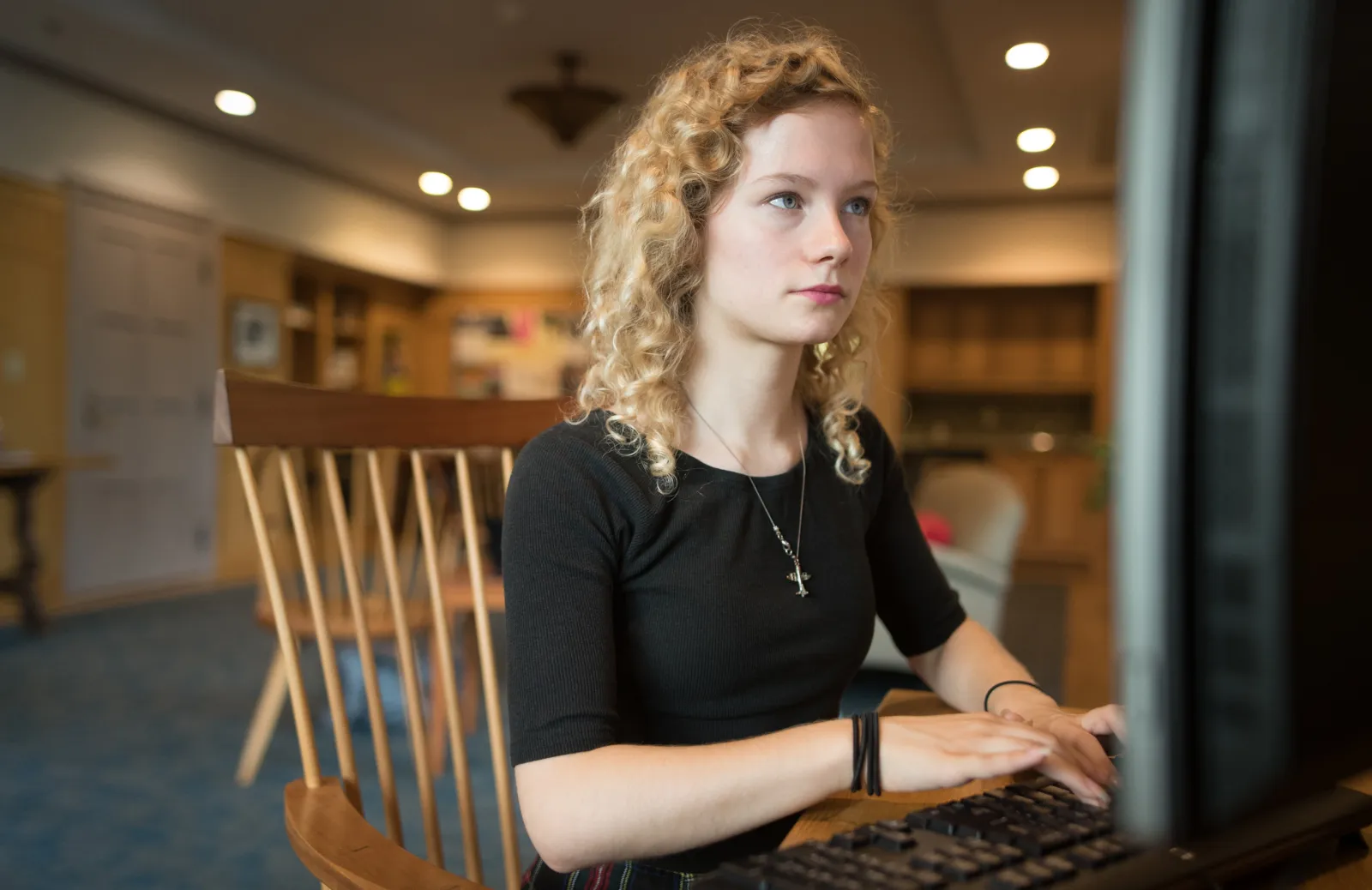 A computer science student sits behind a computer screen