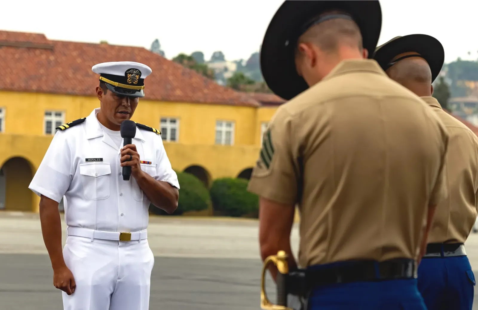 Chaplain Eliseo Morales delivering an invocation during a Marine Corps graduation.