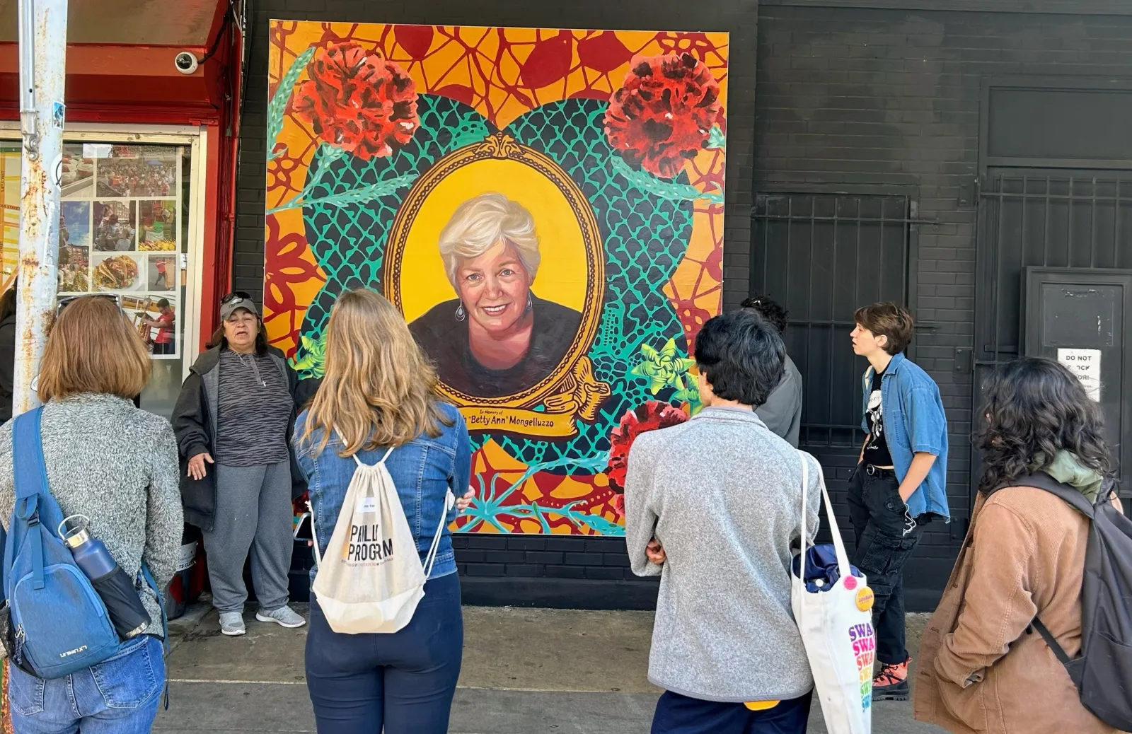 Photo of students look at mural.
