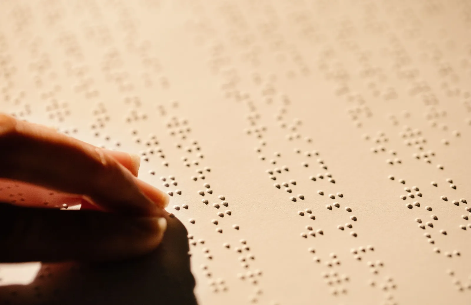fingers on a page reading braille by touch
