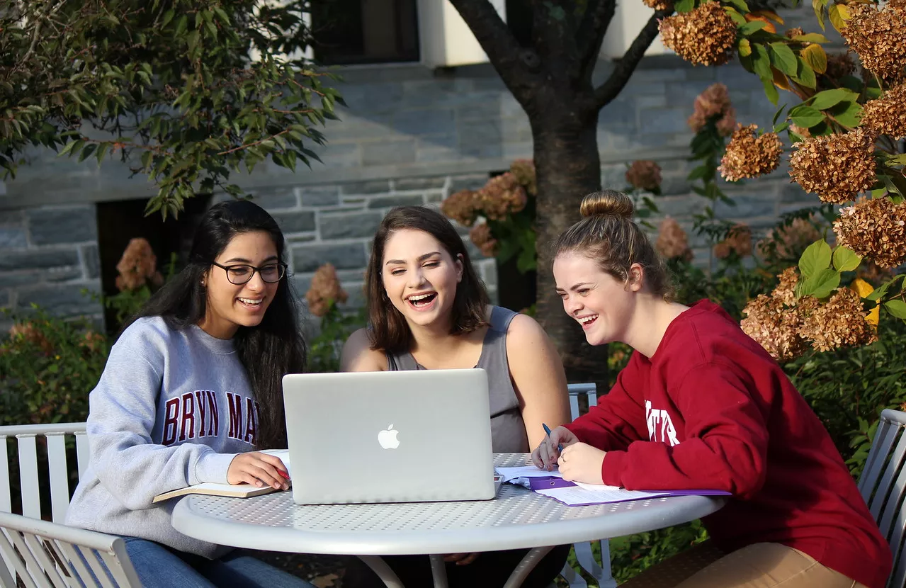 Three students look at computer