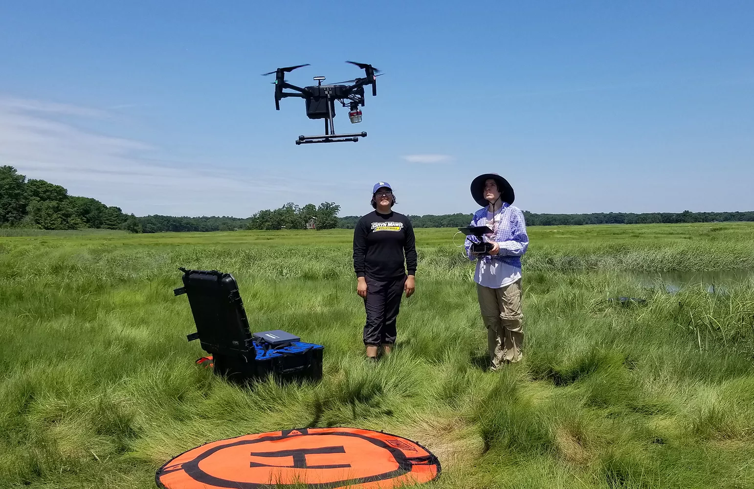 Jocelyn Bravo and Angela Kaurin operate a drone in the marshlands of the Plum Island sound.