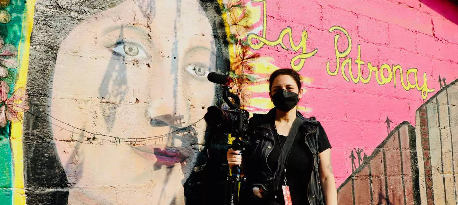Tania Romero at Las Patronas, in front of a wall mural