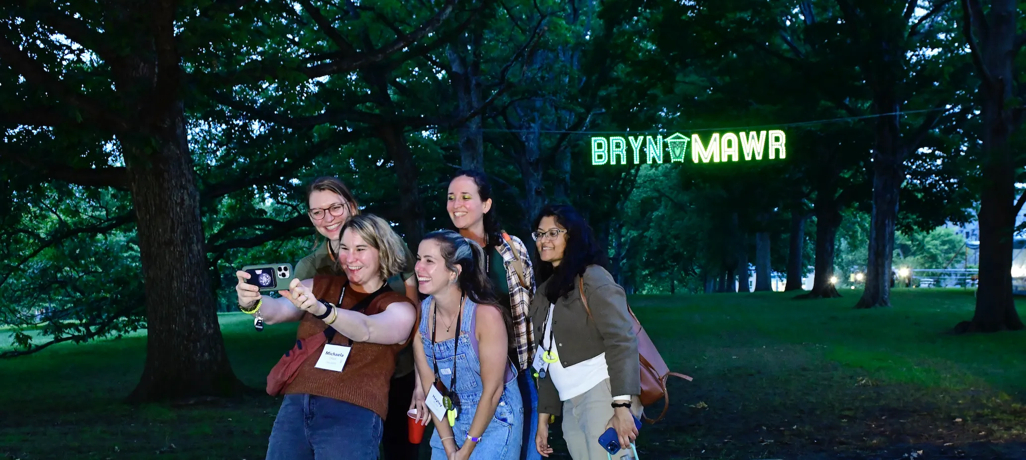 Alums taking a selfie in front of a Bryn Mawr sign
