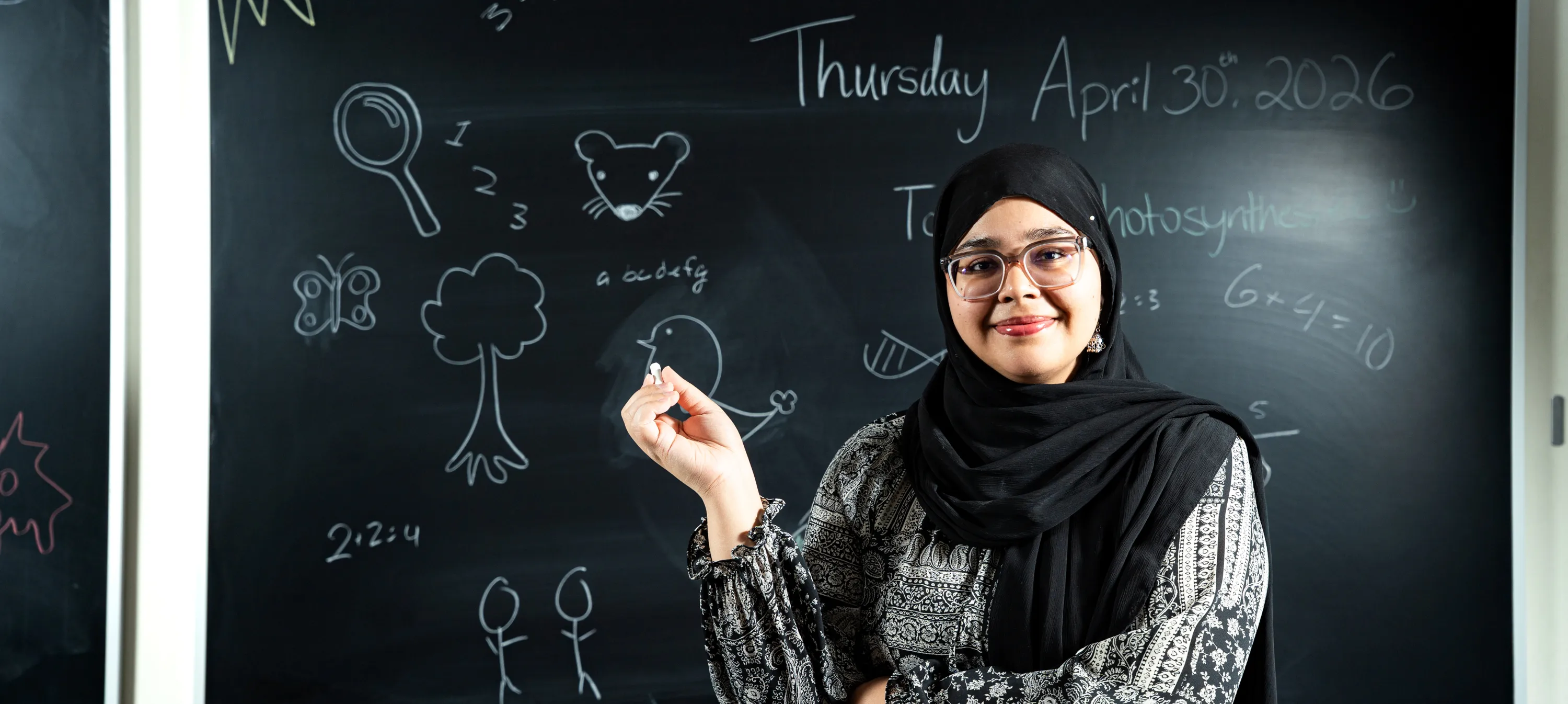 Mahnoor in front of a blackboard