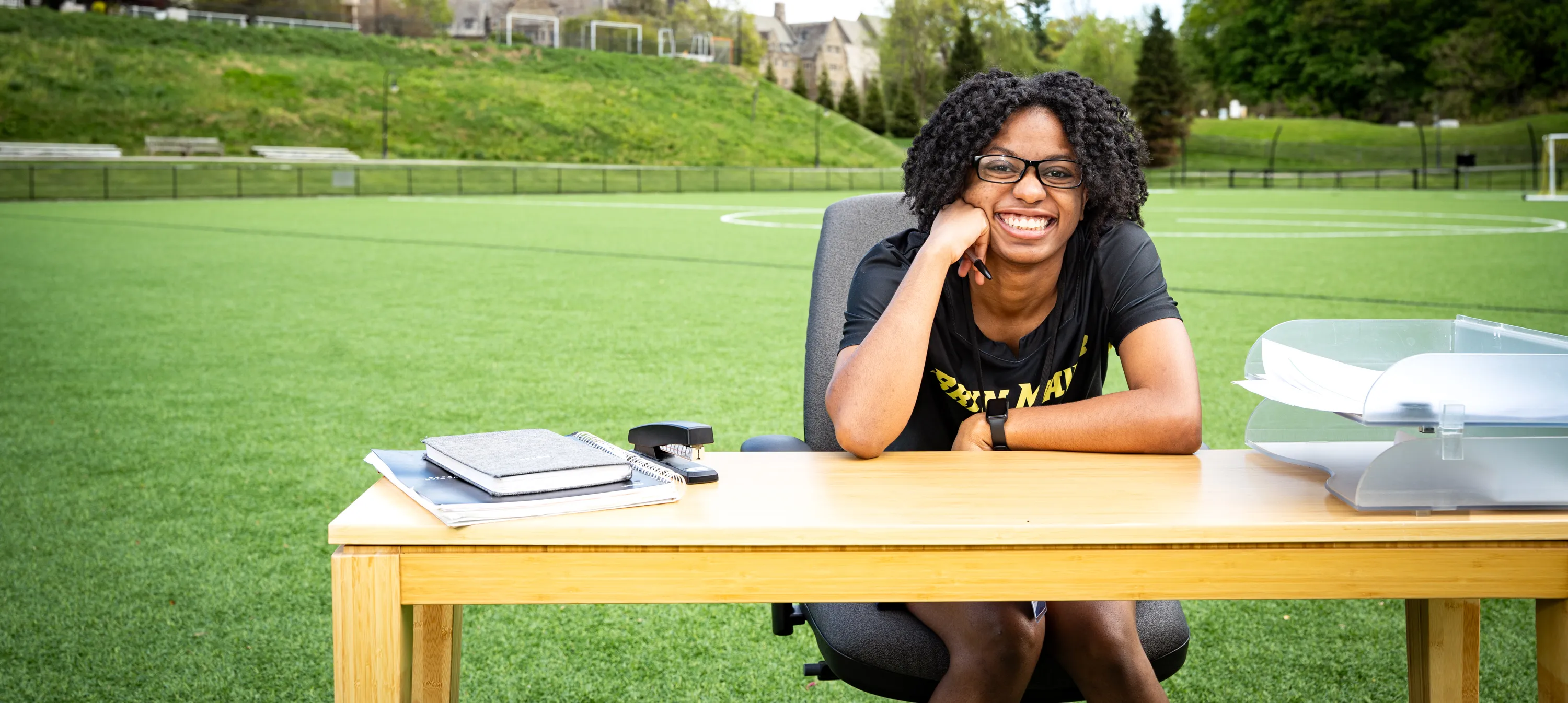 Erica at a desk on the athletic field