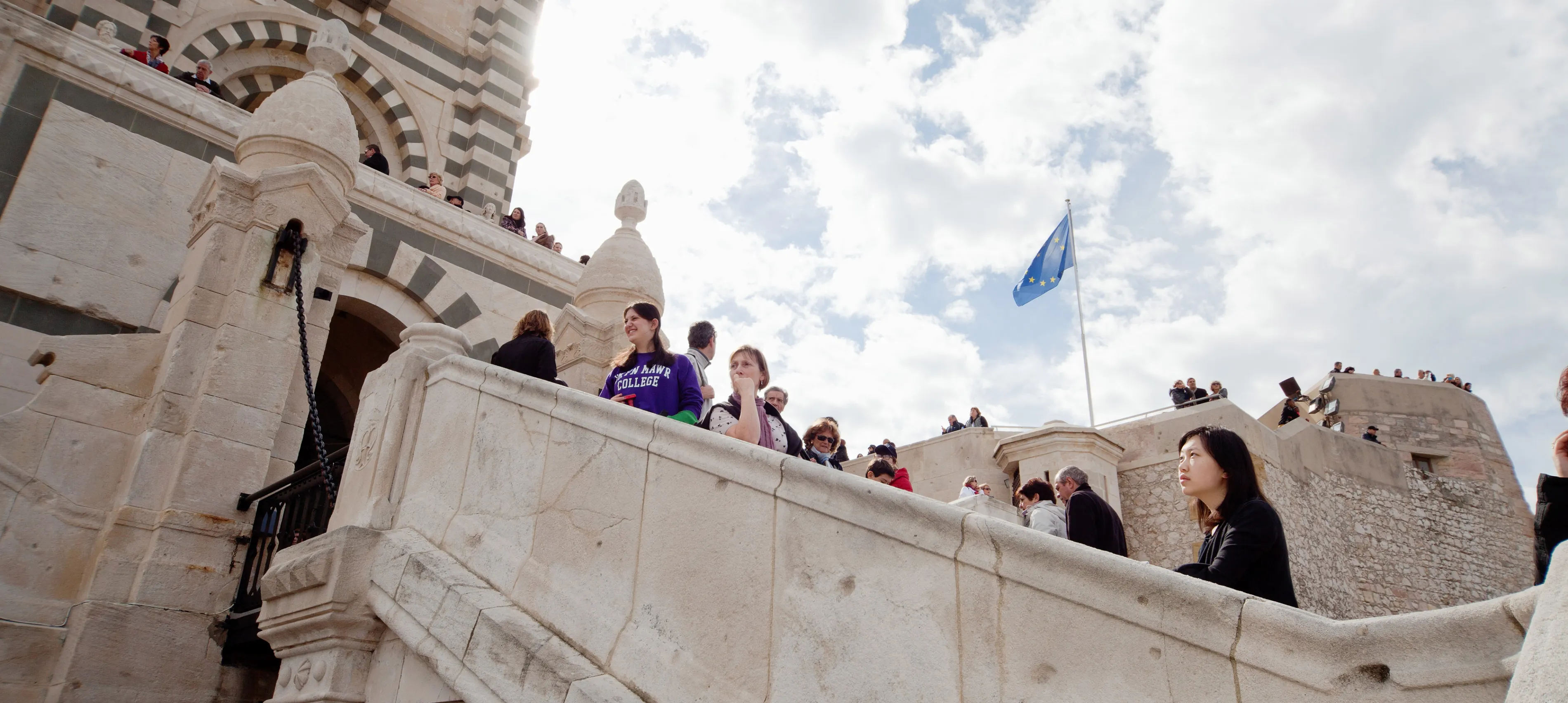 Bryn Mawr College French and Francophone Studies students on the stairs of a large building in Marseille France. 