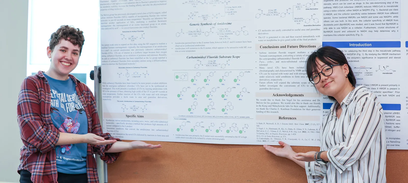 Two chemistry students show off their research poster