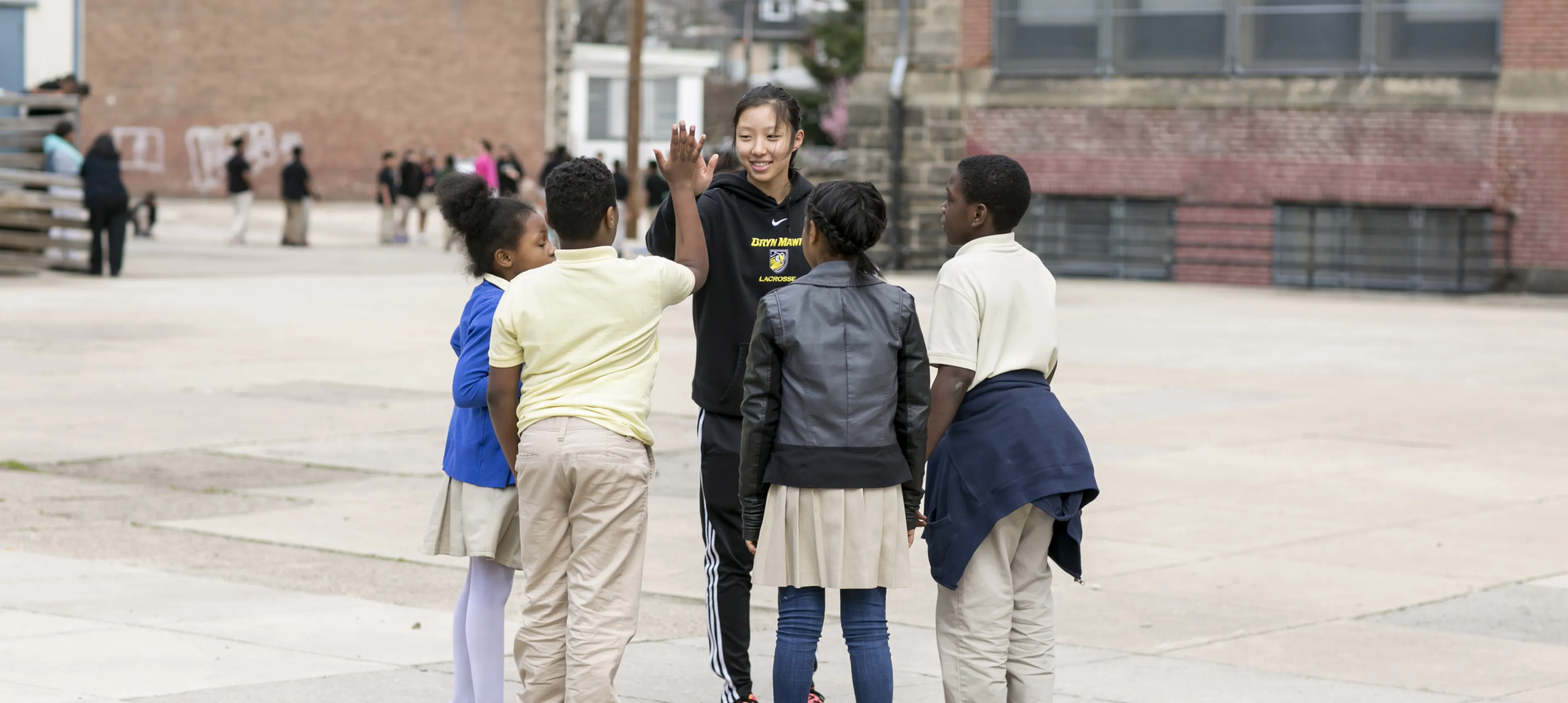 A BMC Education student with children at a school