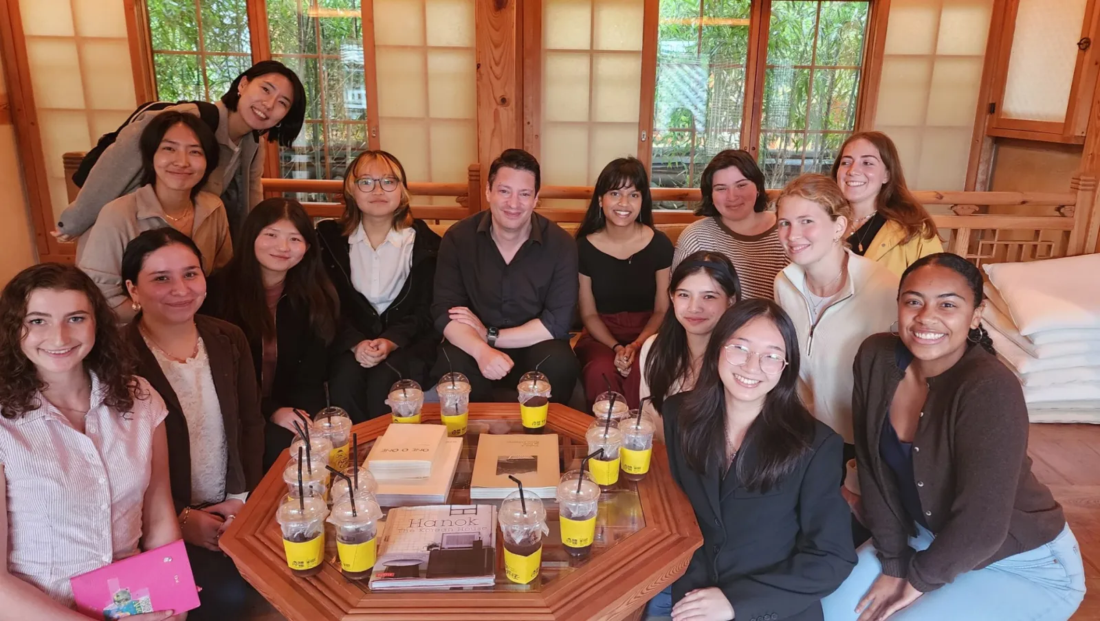 A group of students sit around a table in a traditional room
