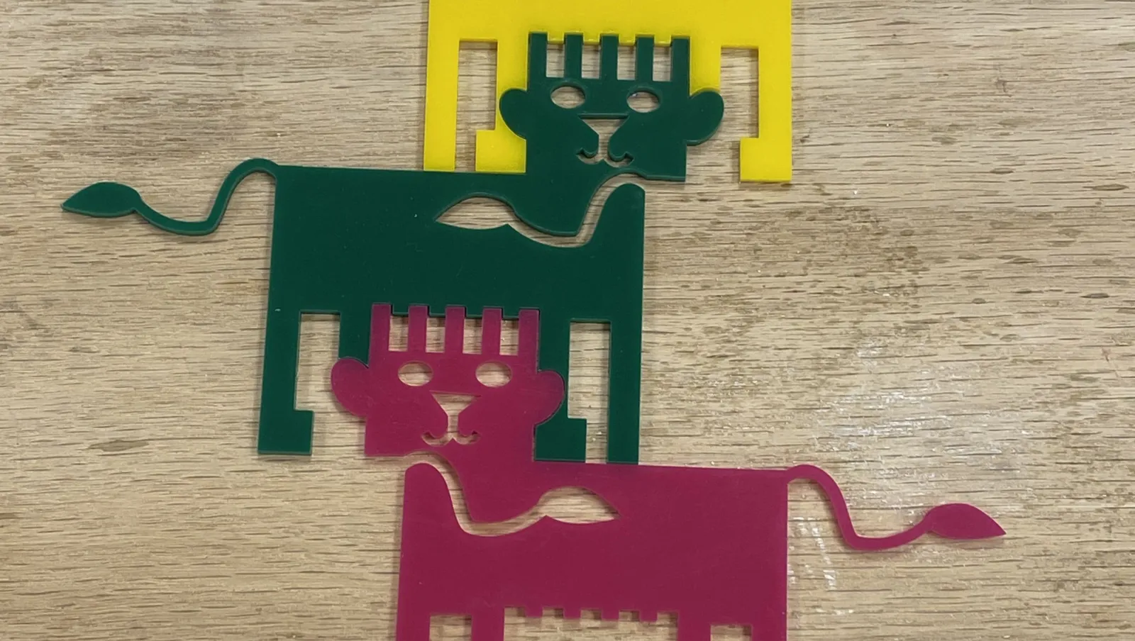 Three tessellated acrylic lions fitted together onto a table