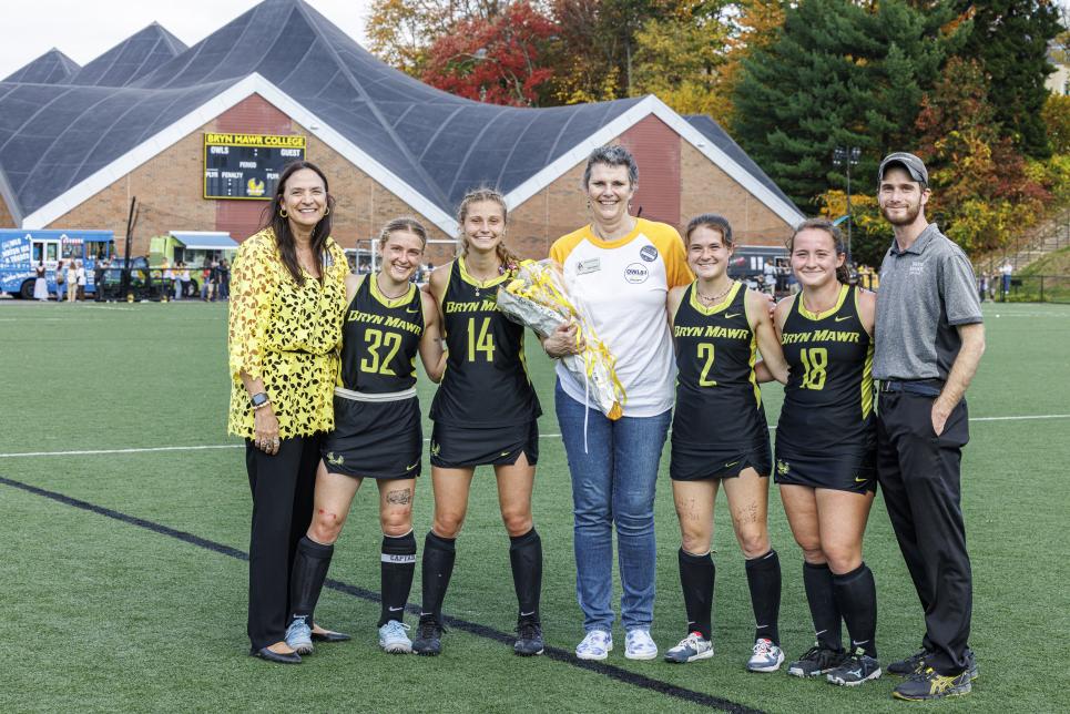 Group photo with field hockey athletes, President Cassidy, Cristina Fink, and Coach Victor Brady