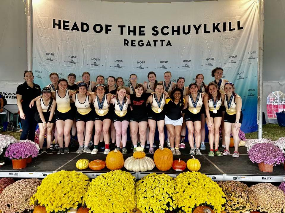 Group photo of the Rowing team in front of the "Head of The Schuylkill" Photo Banner