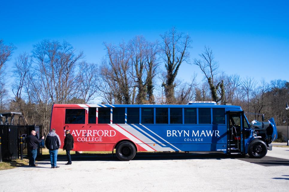 A side view of the electric bus wrapped in blue and red for Bryn Mawr and Haverford.