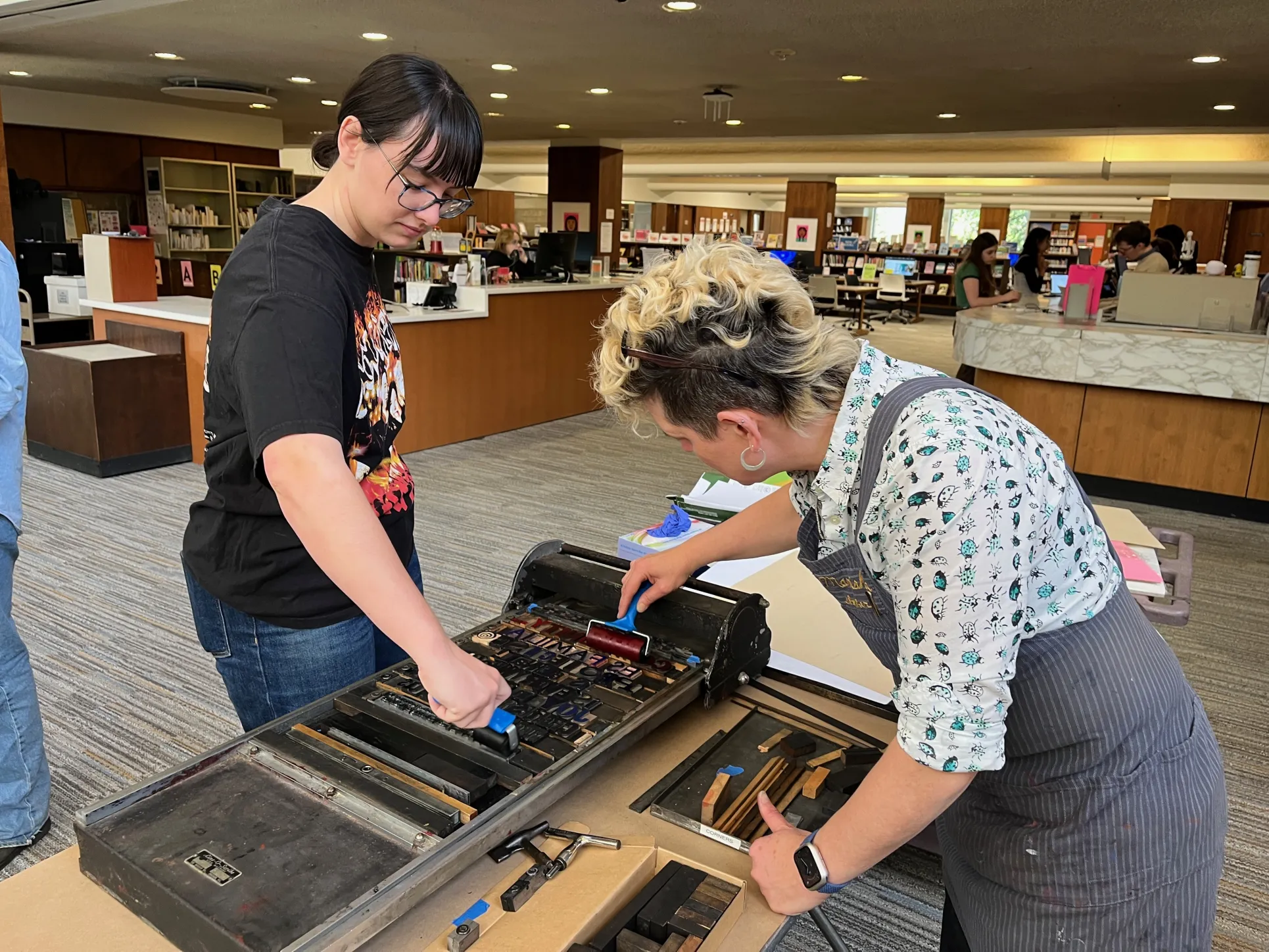 Student helps to ink letterpress blocks 