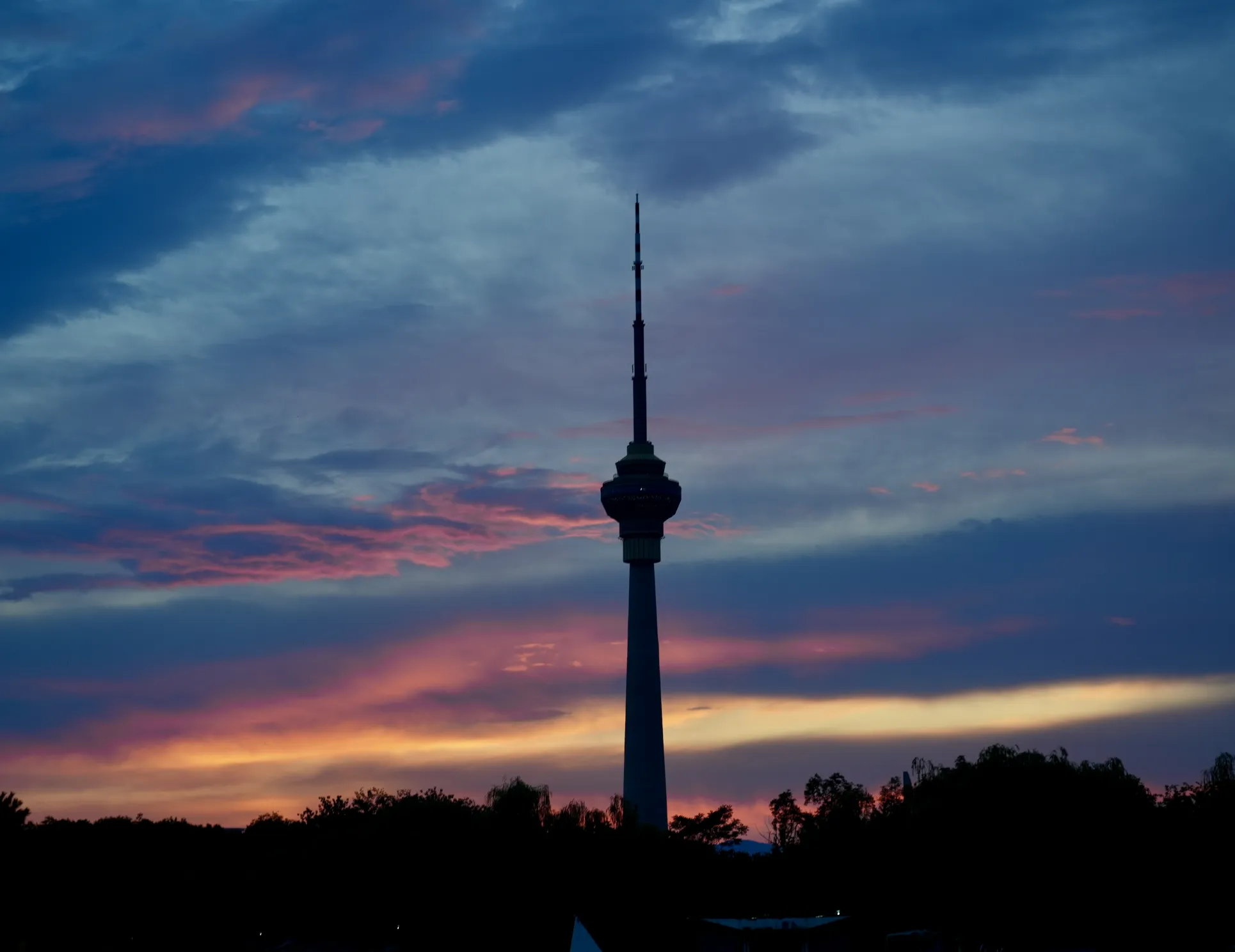 a CCTV tower in Beijing contrasting with a sunset