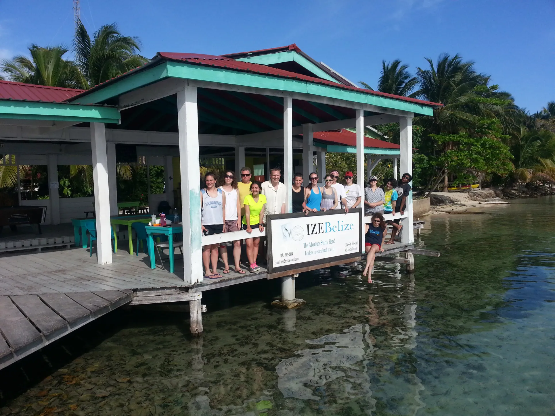 A group of Environmental Science students and professors stand on a dock in Belize