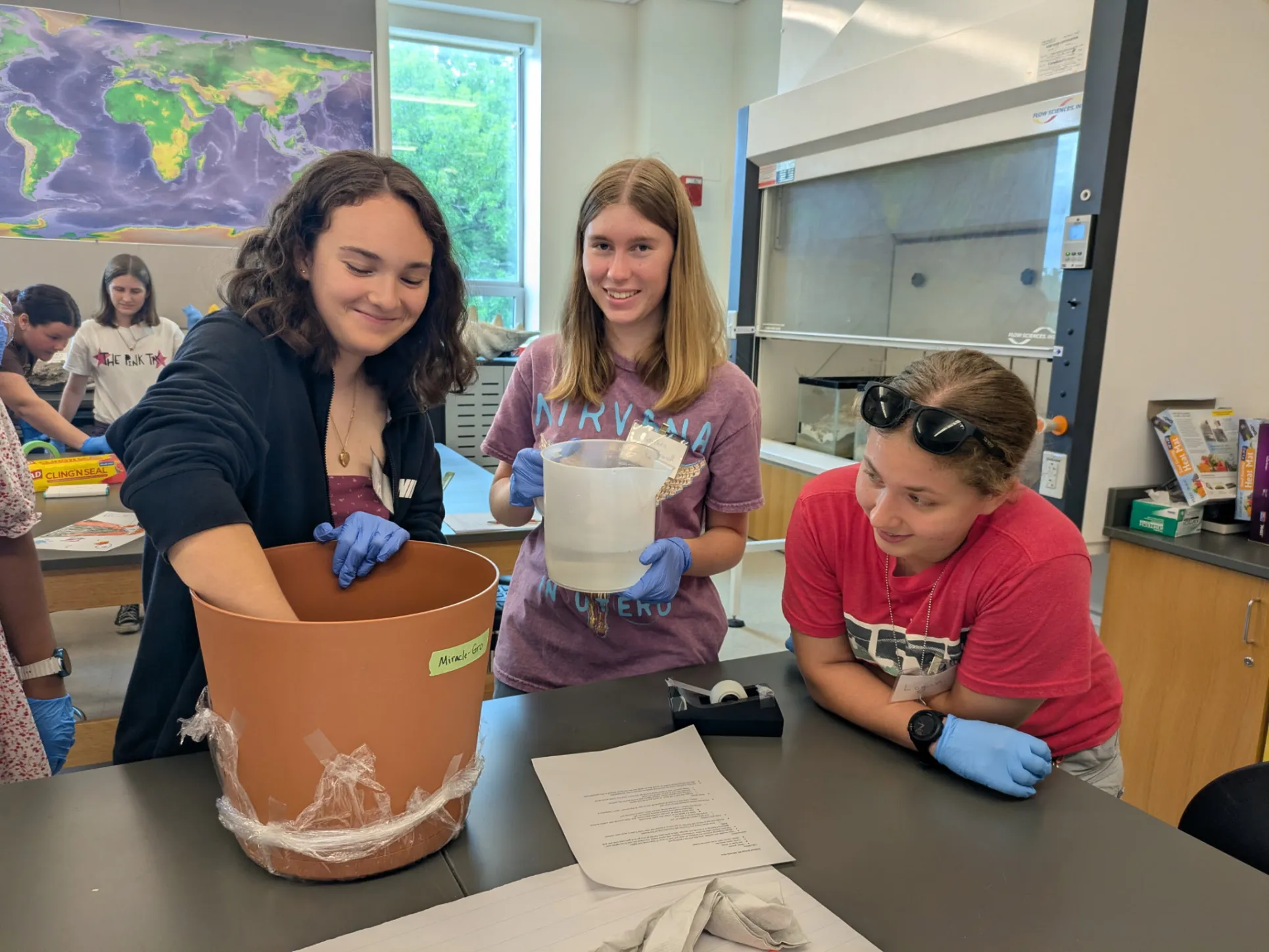 STEMLA fellows fill pots of soil in class