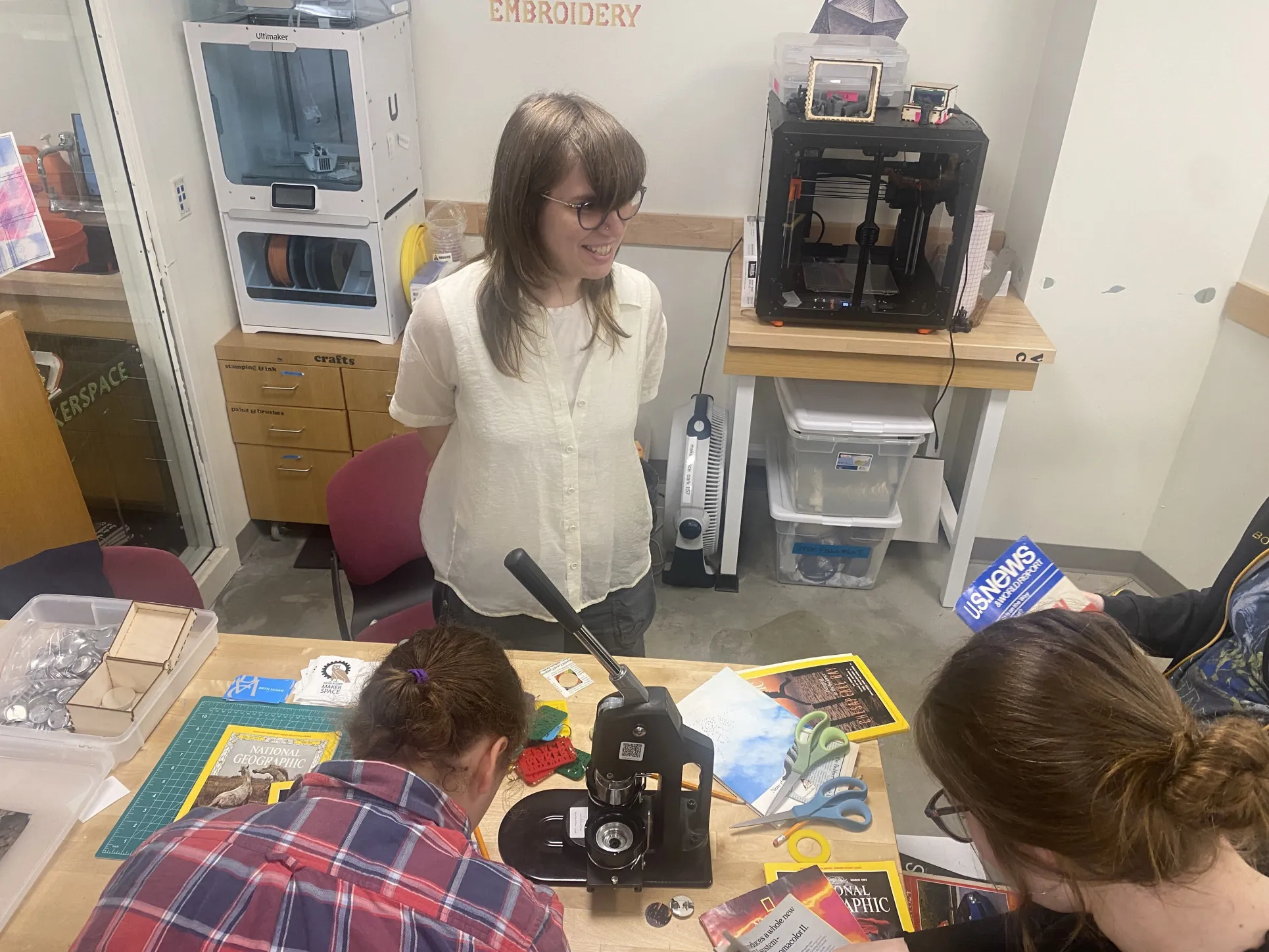 Annika Bergstrom, EAST Educational Technology Assistant, answers questions from students on how to use the button maker