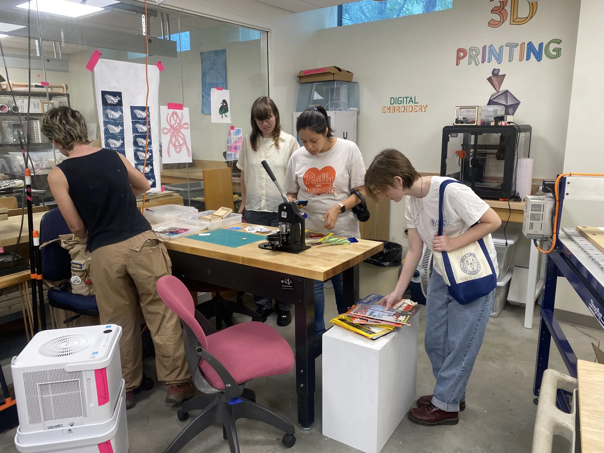 Annika Bergstrom, EAST Educational Technology Assistant, and students look at Makerspace devices