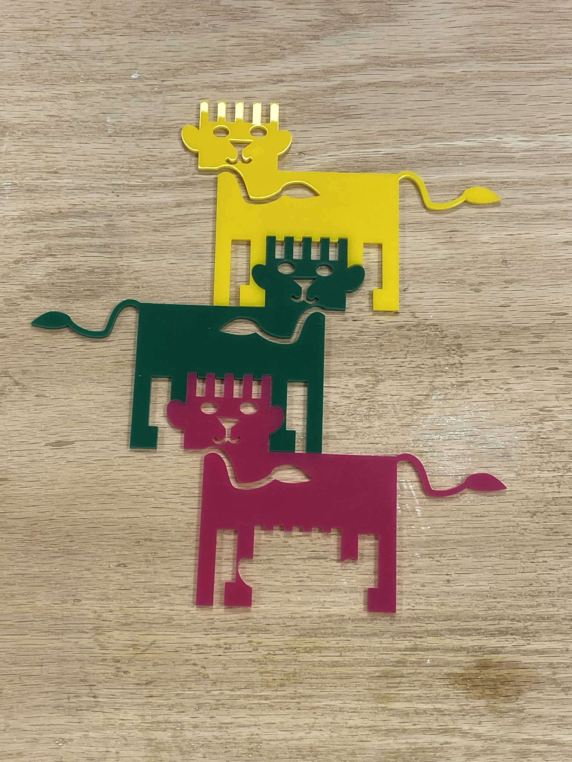 Three tessellated acrylic lions fitted together onto a table