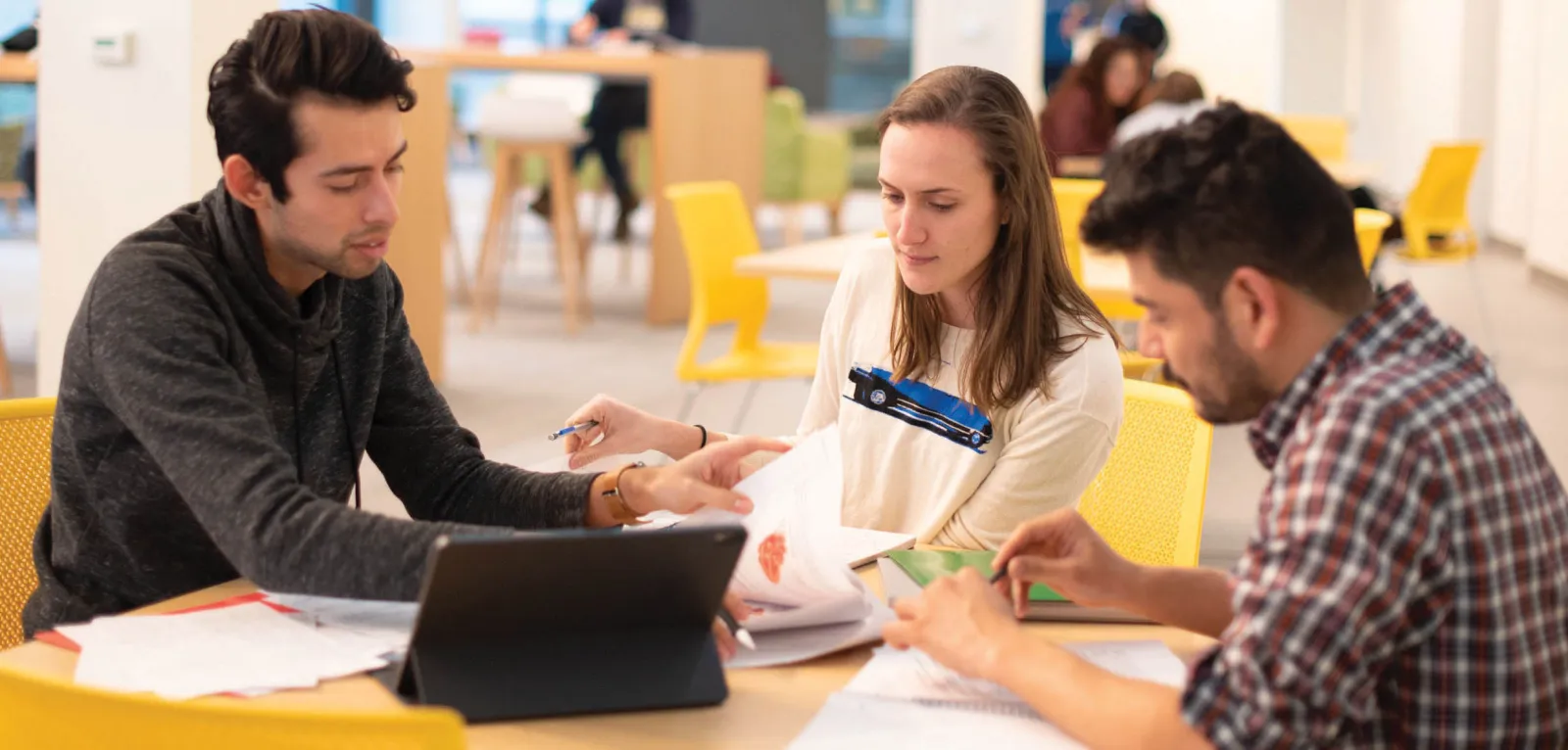Three students sitting around a table studying