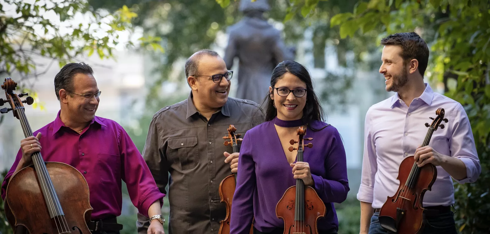 Four musicians holding string instruments