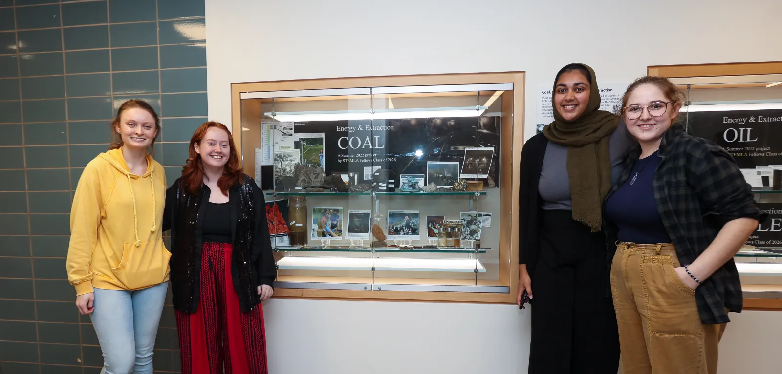 STEMLA Fellows post in front of display case