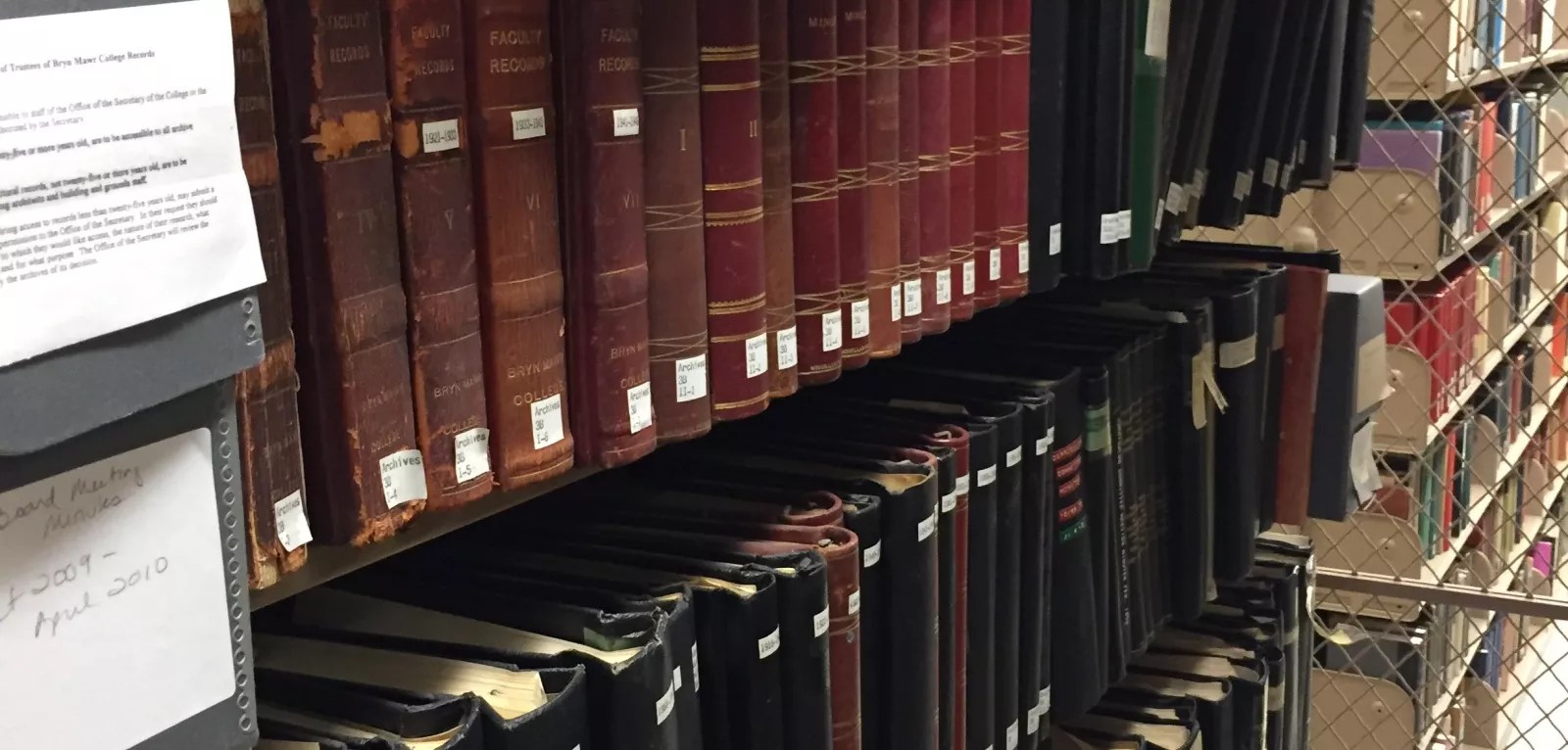 Image of hollinger boxes and bound volumes on shelf.