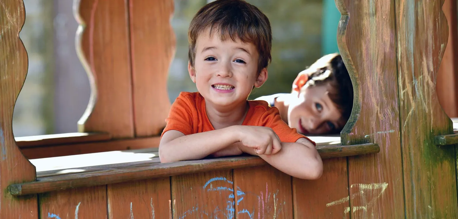 Two boys posing on a wooden ledge