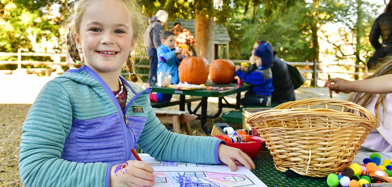 Girl at picnic table coloring in a book
