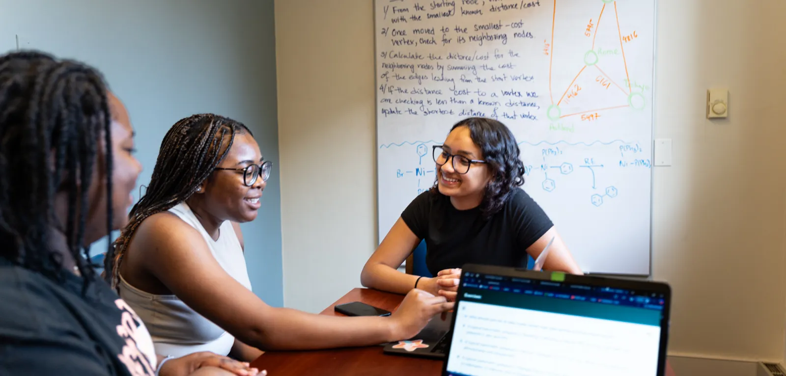 Three students work on computer science in the quantitative q center