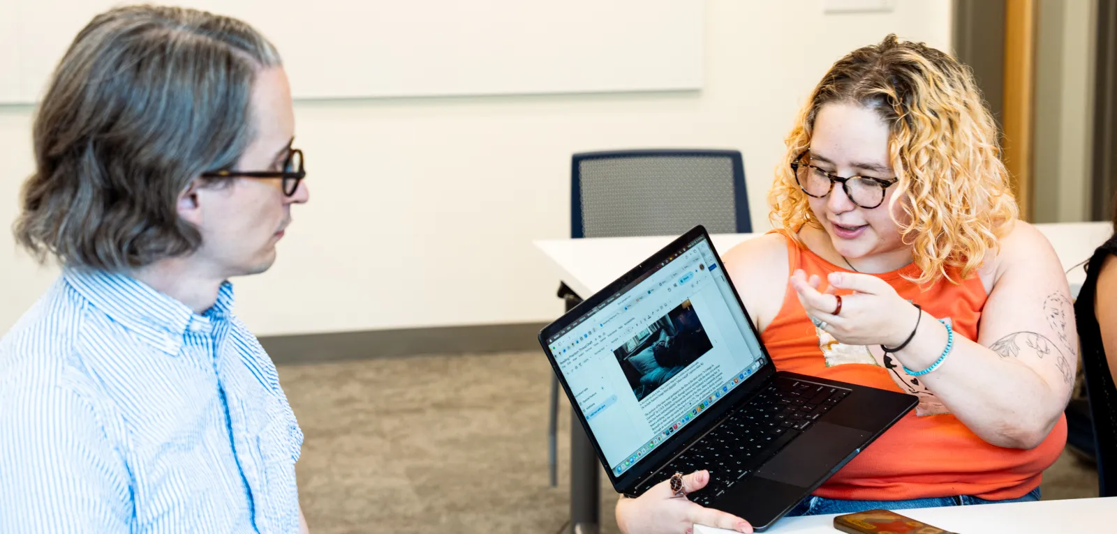 Student discussing digital humanities project with professor
