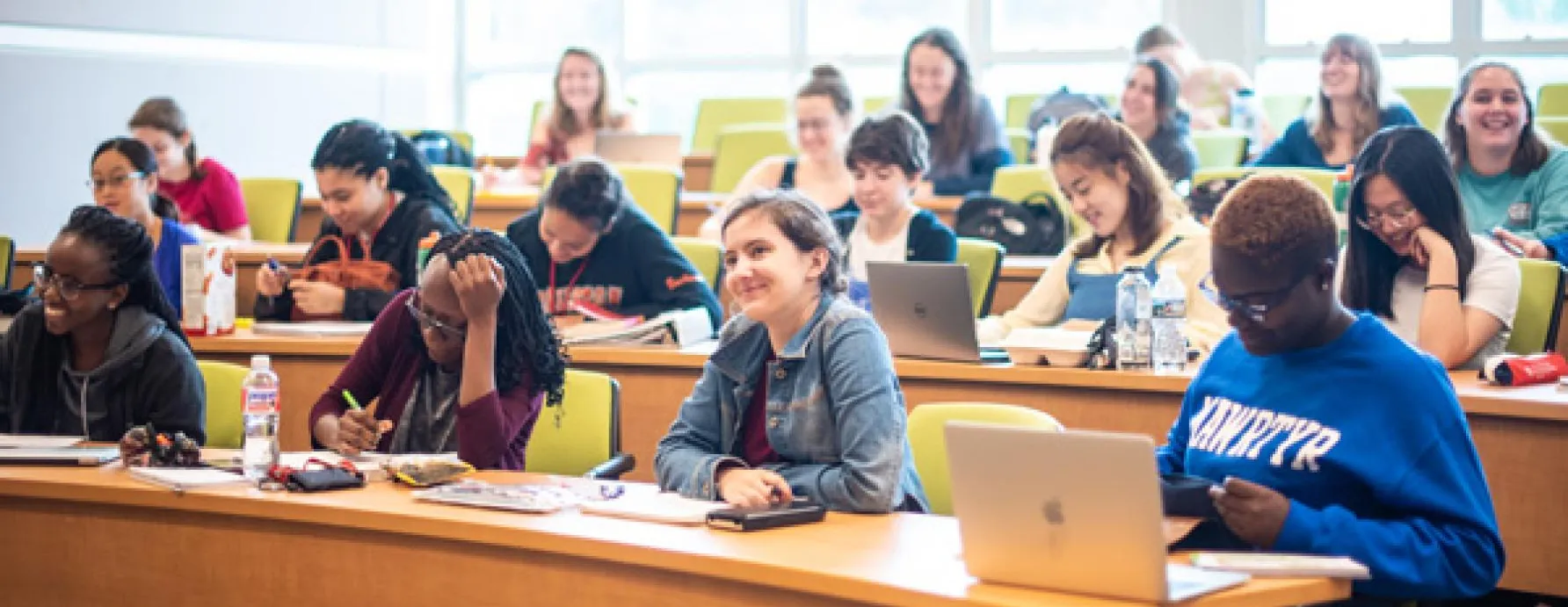 Students with laptops in a classroom learning