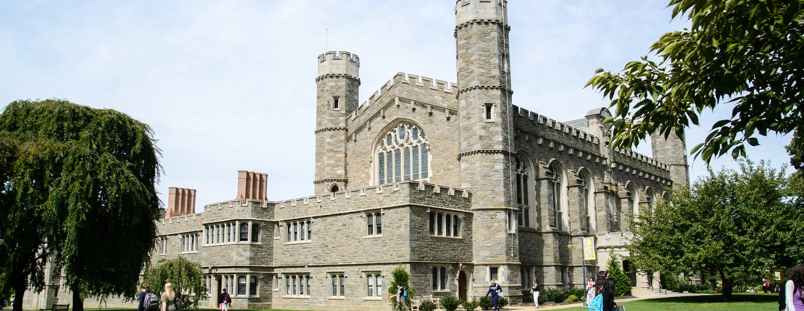 Large stone building with students walking across lawn