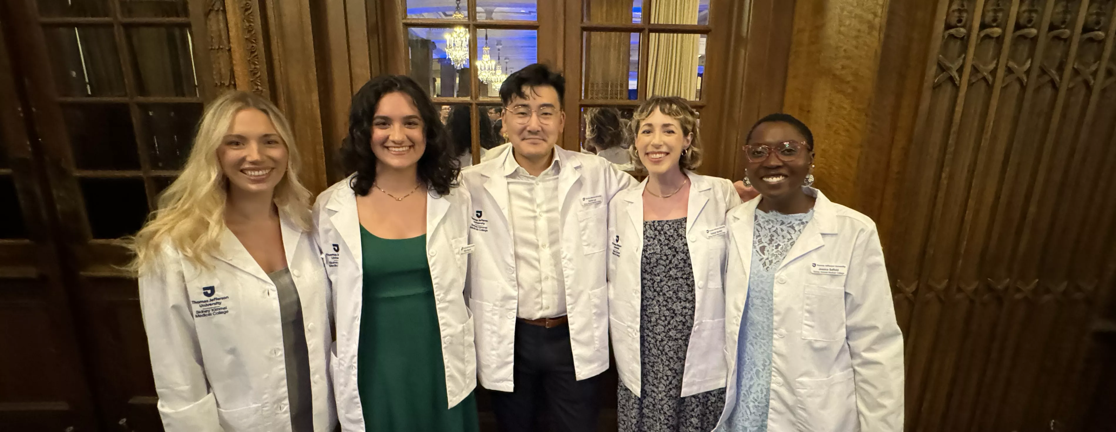 Group of smiling students wearing med student white coats
