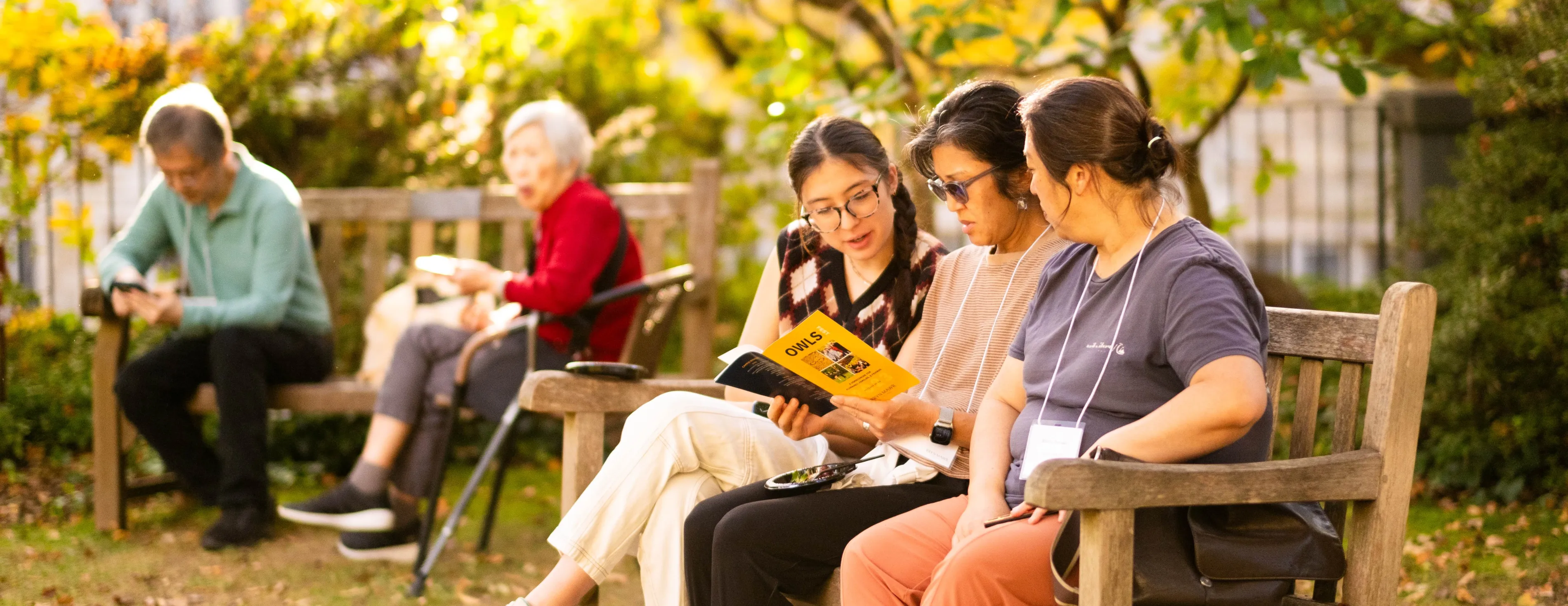 People sitting on a bench reading